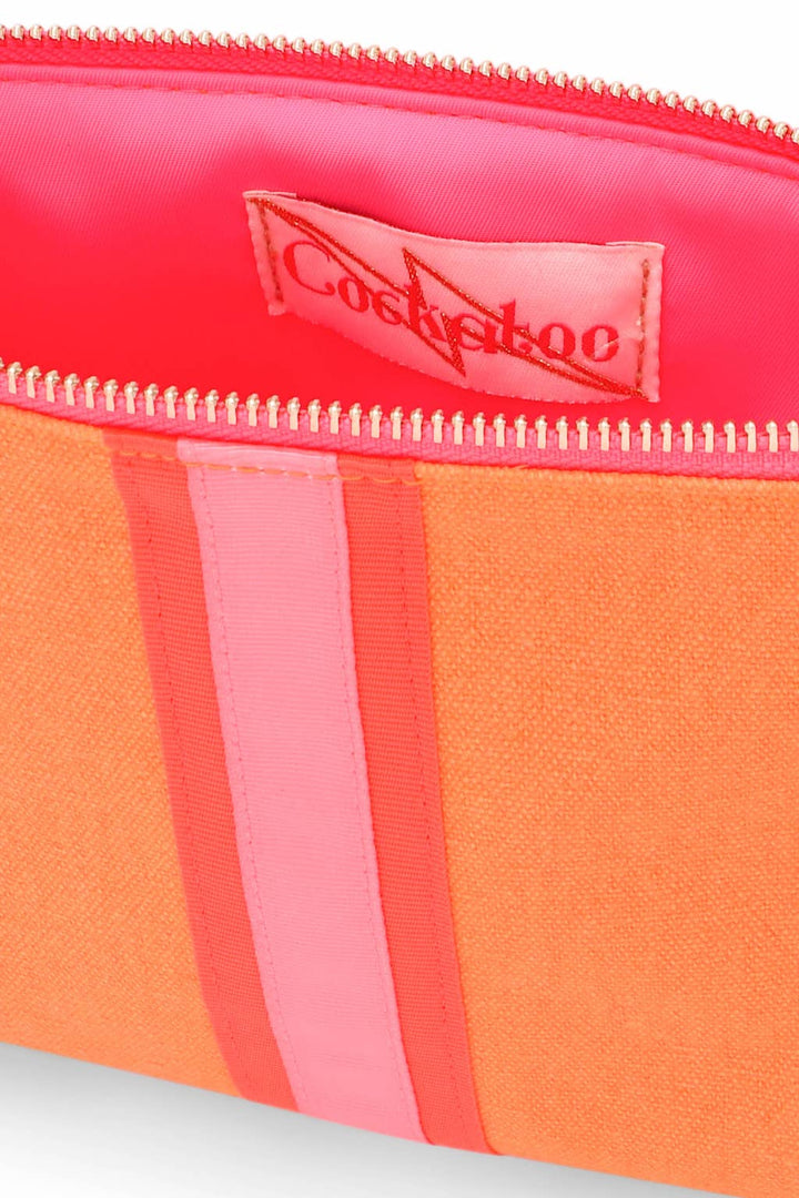 Section of a bright orange clutch bag with the zip open to show bright pink lining.