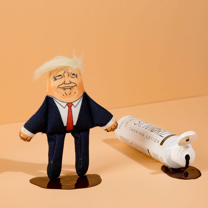 Toy figure of a person in a suit with a bottle labeled 'Surreal' on a beige background