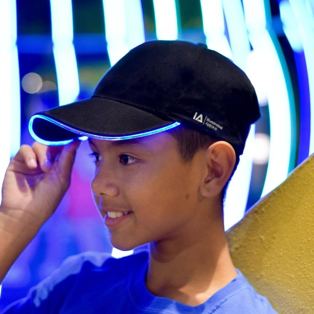 Child wearing a black cap with a logo against a colorful background