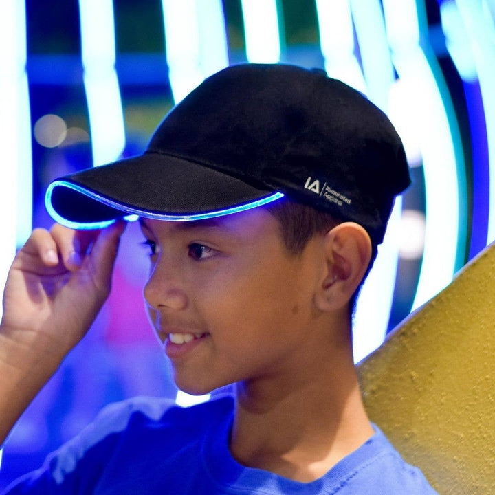 Child wearing a black cap with a logo against a colorful background