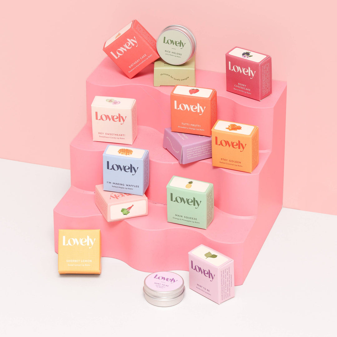 Collection of 'Lovely' product boxes on a pink platform with a pink background