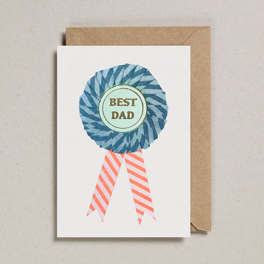A greetings card with a blue rosette and the words 'Best Dad' in the middle.