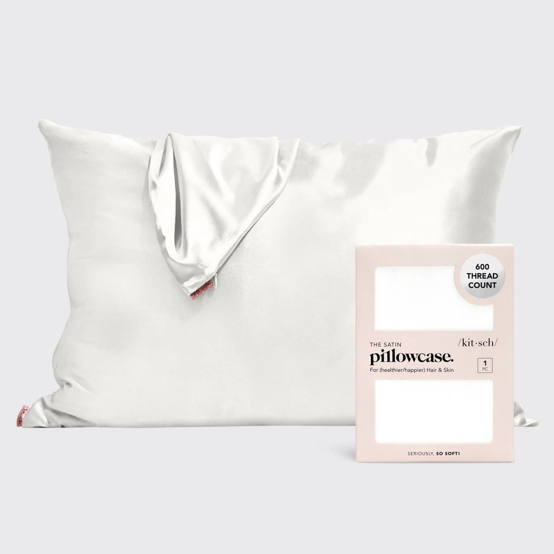White satin pillowcase with packaging on a light gray background