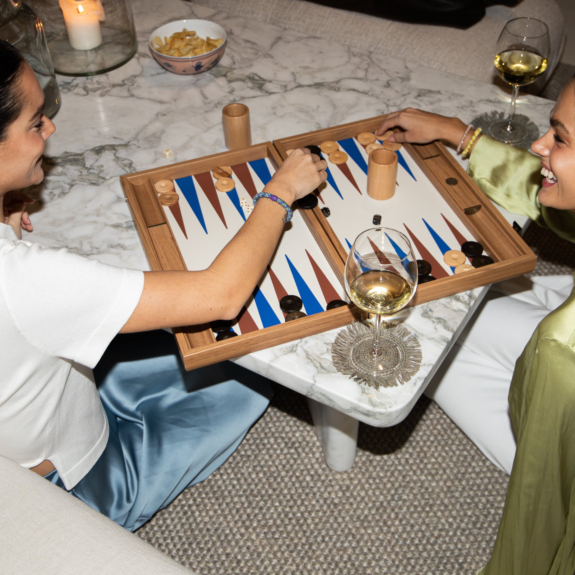 girls wearing Kknekki hairbands playing backgammon drinking wine