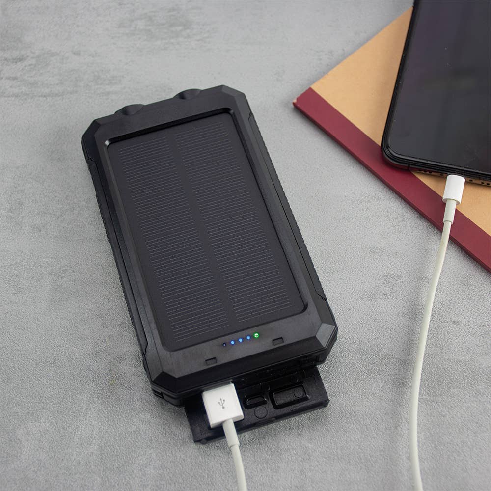 Black solar charger with USB cable on a gray surface