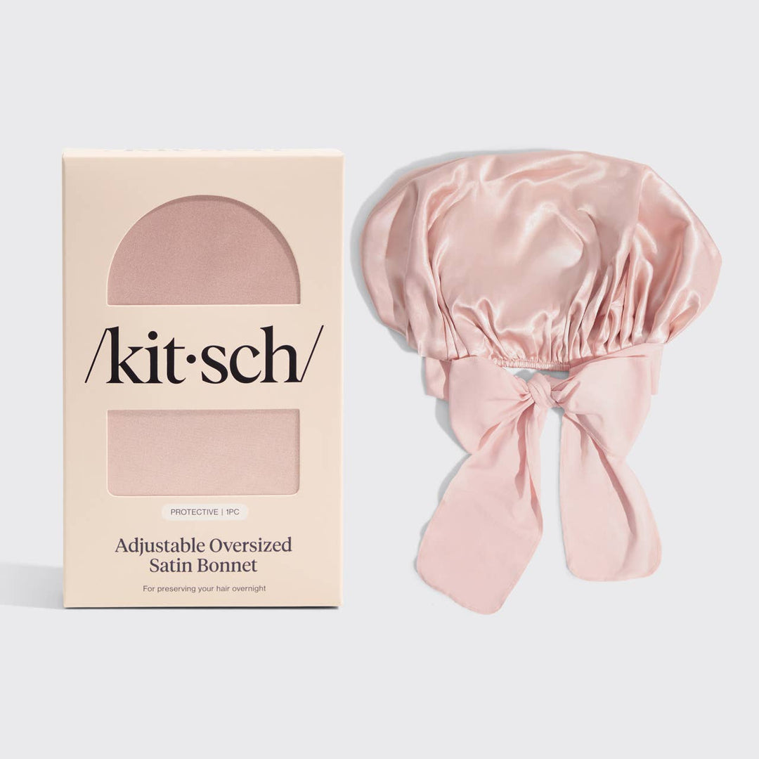 Pink satin bonnet with 'kit·sch' packaging on a light gray background