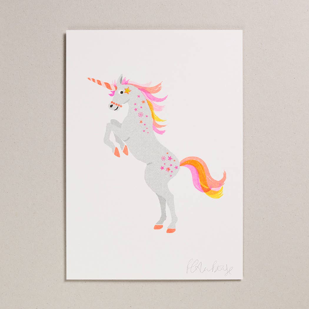 A greetings card picturing a rearing white unicorn with a pink orange and yellow mane and tail.