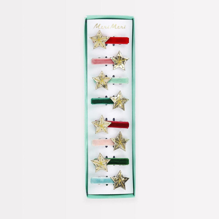 A set of eight hair clips with gold stars and colored velvet ribbons presented in a box.