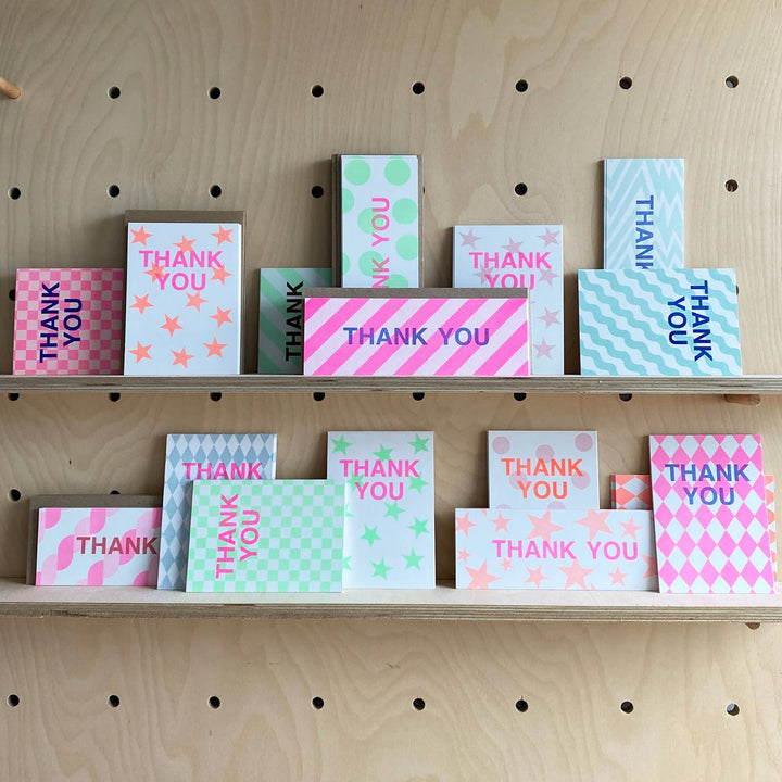 Collection of 'THANK YOU' cards with various patterns on a wooden shelf.