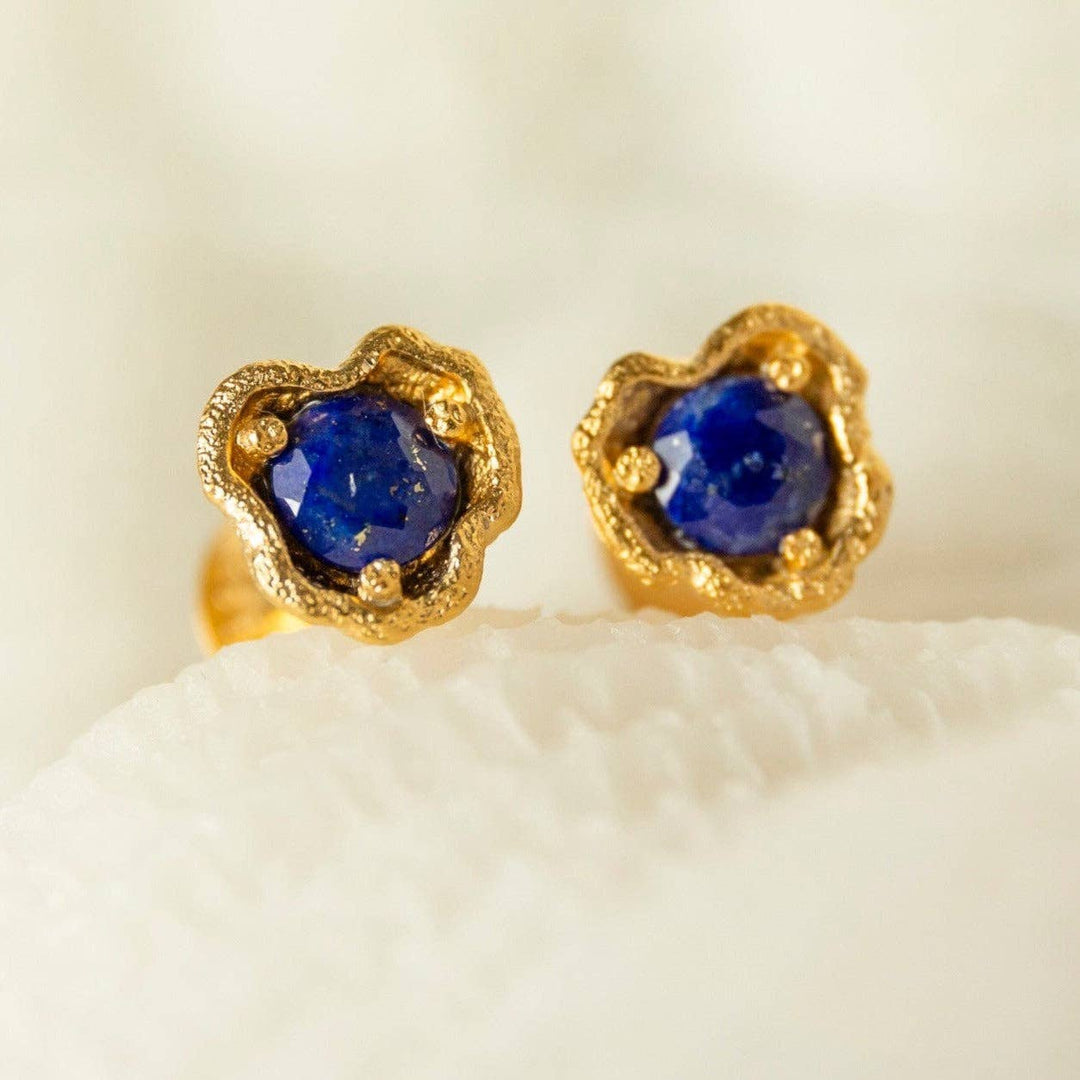 A pair of gold vermeil stud earrings with lapis lazuli set in a textured gold design, displayed against a light background.