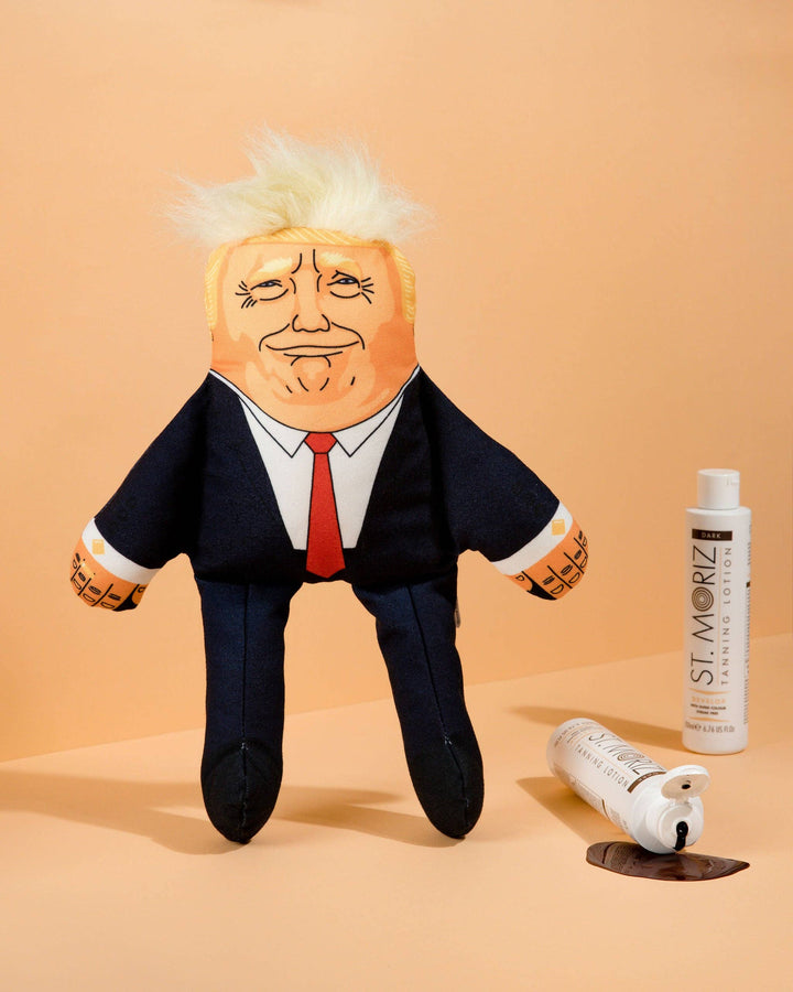 Plush toy resembling a political figure on a beige background with St. Moriz hair care products.