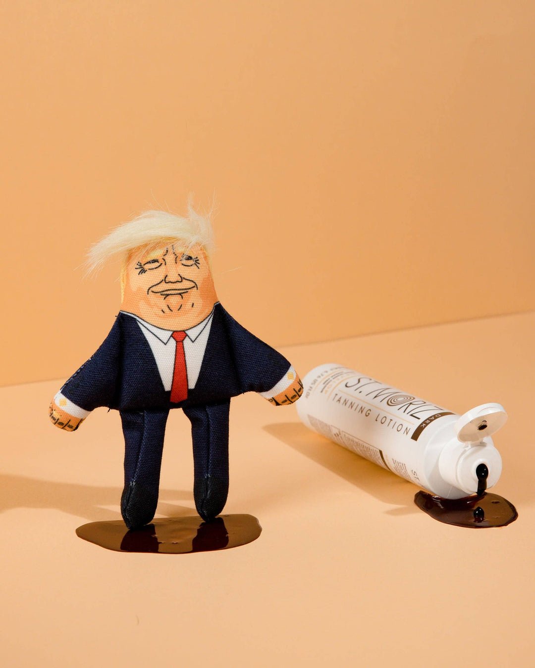 Toy figure of a person in a suit with a bottle labeled 'Surreal' on a beige background