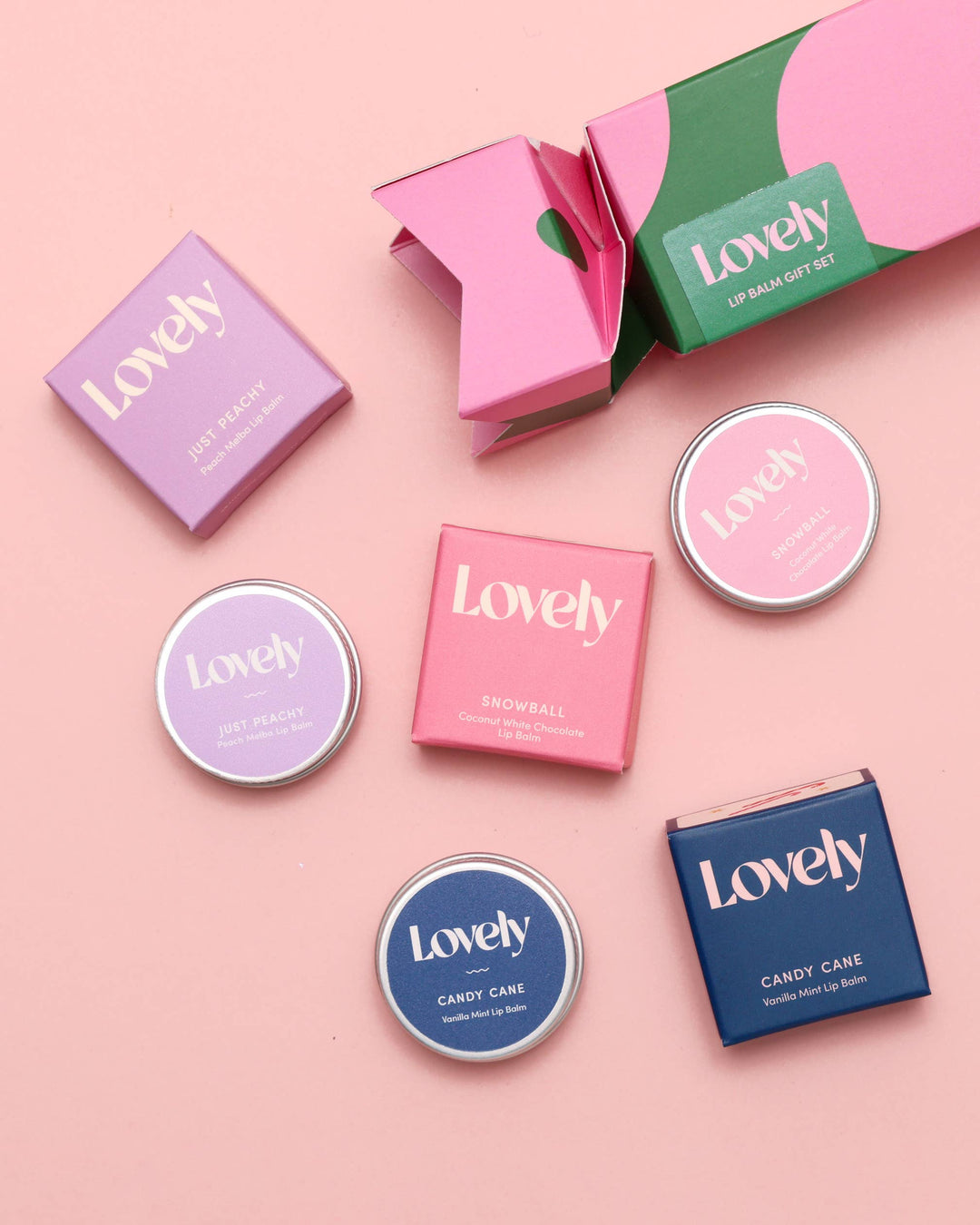 Collection of 'Lovely' lip balm tins on a pink background