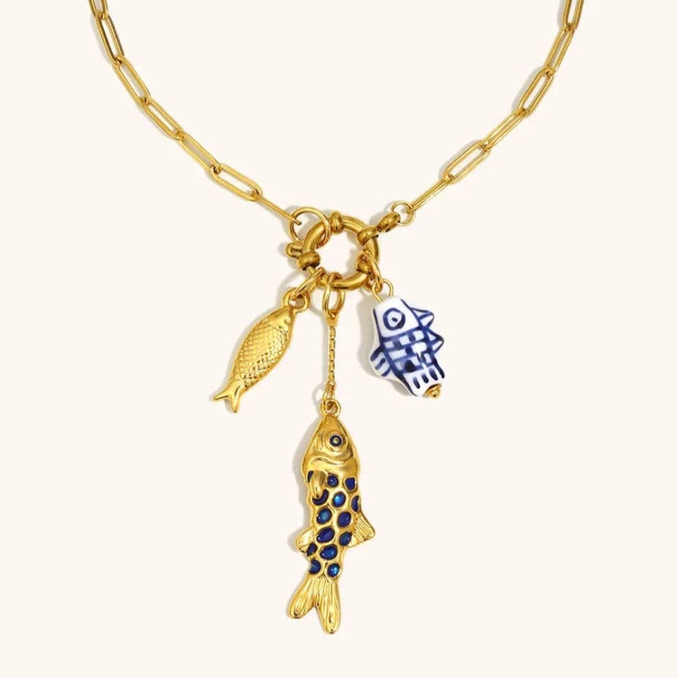 Gold necklace with fish charms on a white background
