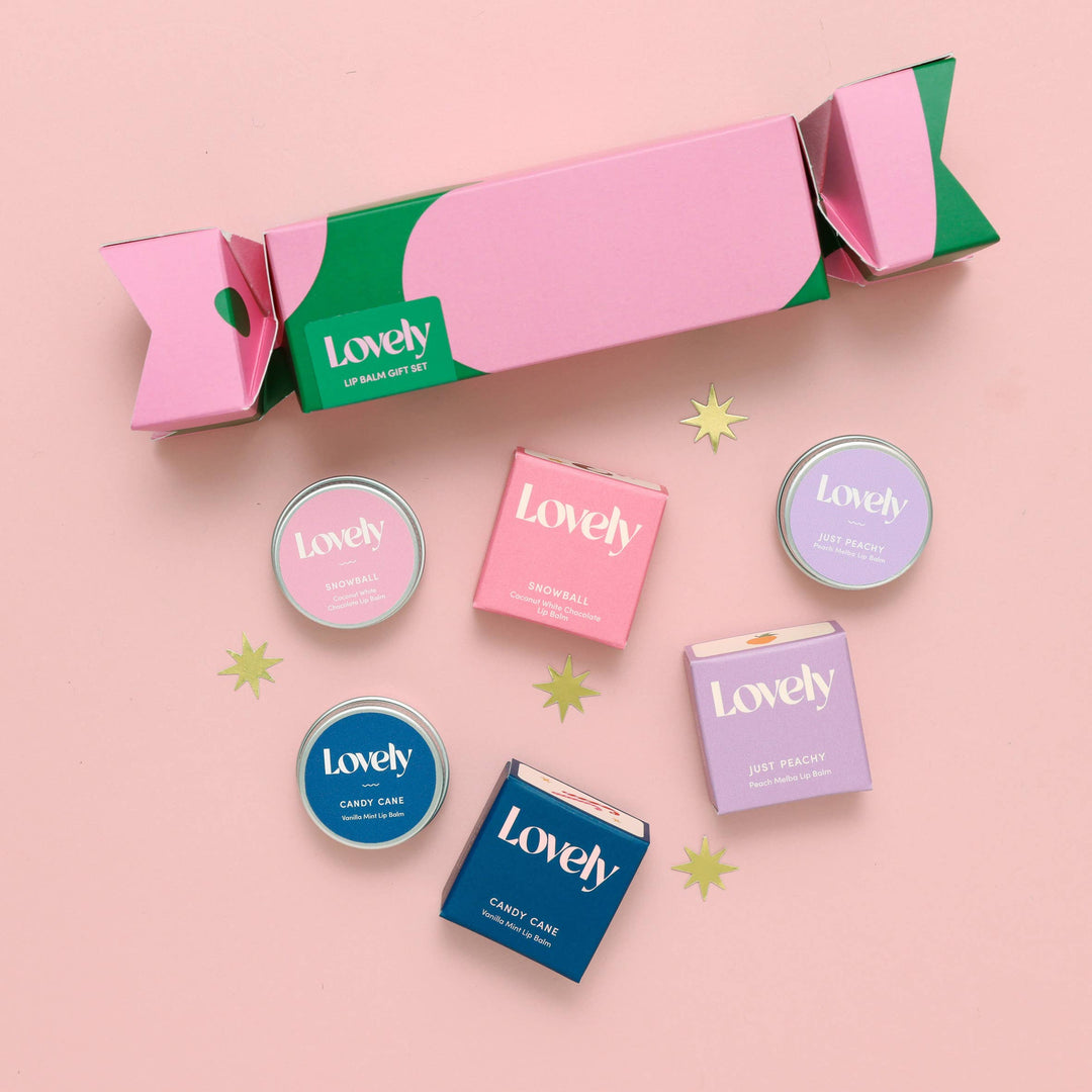 Set of 'Lovely' lip balm containers on a pink background