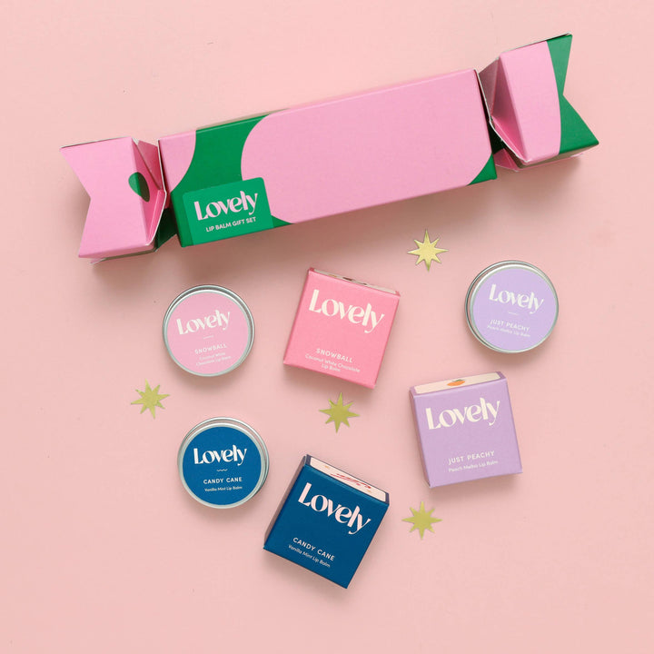 Set of 'Lovely' lip balm containers on a pink background