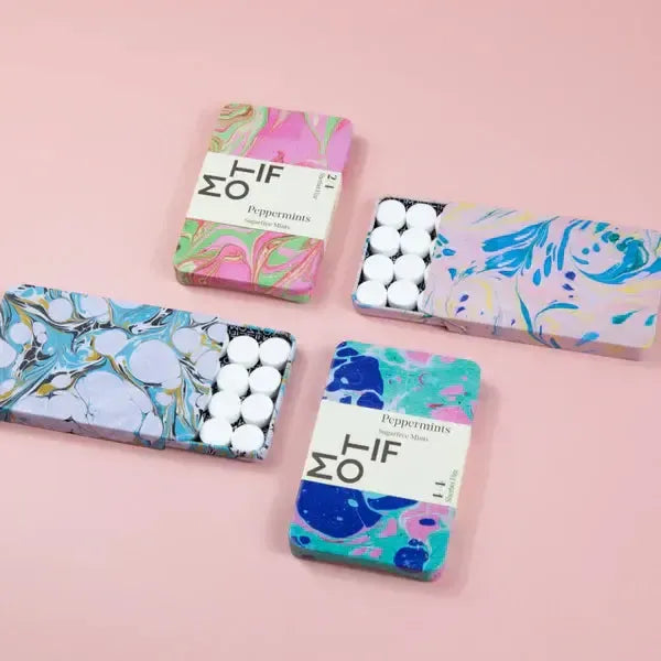 Colorful boxes of peppermints on a pink background