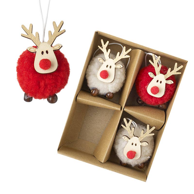 Three Christmas reindeer ornaments displayed next to their brown cardboard gift box. The ornaments feature fluffy red bodies, white fluffy bellies, light wood antlers and snout, and red pom-pom style noses with small brown shoes.