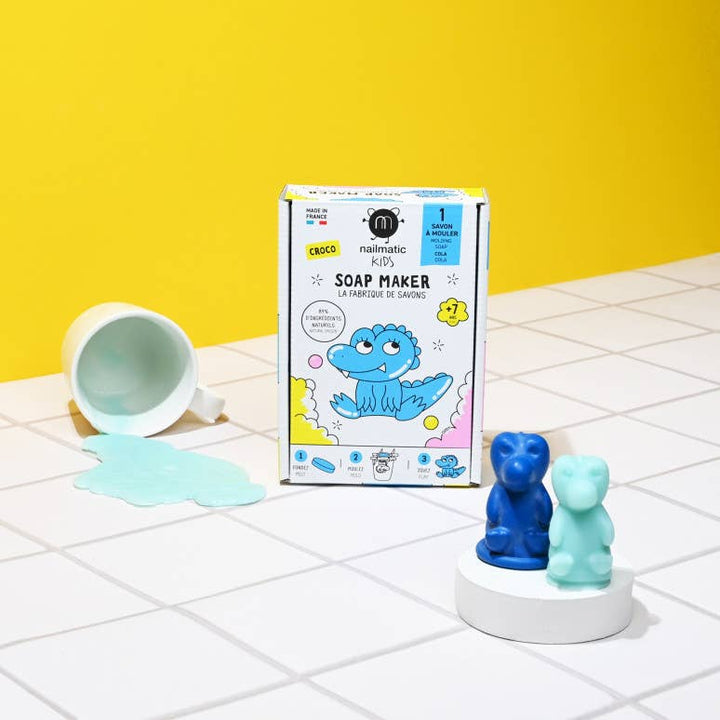 Soap maker kit with dinosaur designs on a tiled floor against a yellow wall